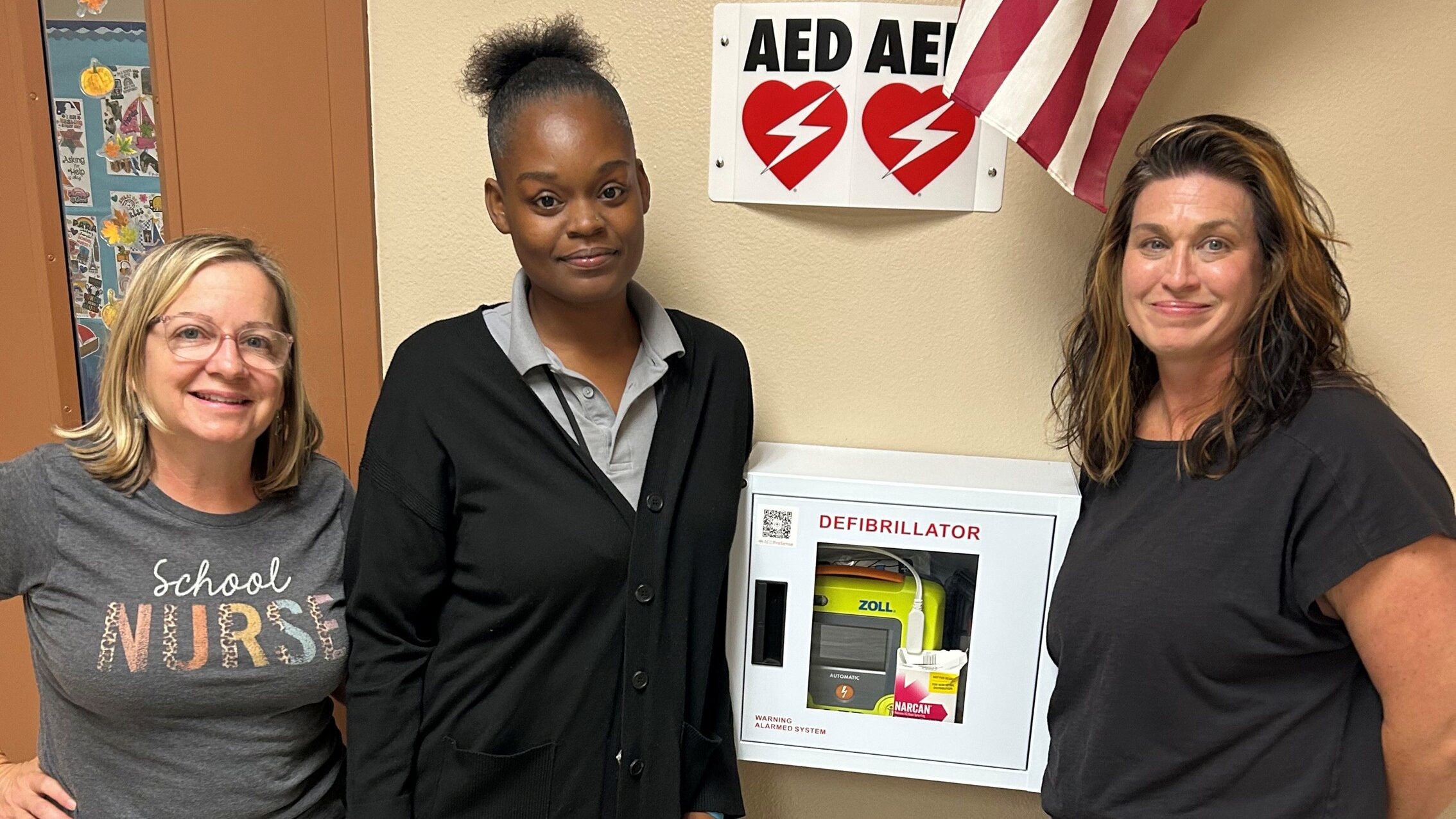 Rhonda Smorong, Shanta Winters, and Mary Green in front of the ZOLL AED 3
