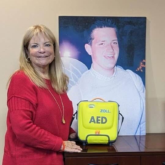 Rachel Moyer next to photo of her son Greg Moyer